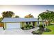 Charming one-story home boasts a lush green lawn, mature landscaping, and a paved walkway at 1010 68Th Nw St, Bradenton, FL 34209