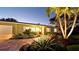 Inviting single-story home with manicured landscaping, a paved walkway, and a cozy, warm light at 1010 68Th Nw St, Bradenton, FL 34209