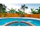 Sparkling pool showcases tropical landscaping with an attractive privacy fence and patio chairs at 1010 68Th Nw St, Bradenton, FL 34209