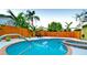 Sparkling pool and spa surrounded by a privacy fence and lush tropical landscaping at 1010 68Th Nw St, Bradenton, FL 34209