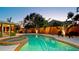 Inviting swimming pool and hot tub, surrounded by tropical landscaping, lit up at dusk at 1010 68Th Nw St, Bradenton, FL 34209