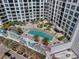 Aerial view of a condo's rooftop pool area, surrounded by palms and upscale apartments at 111 S Pineapple Ave # 813, Sarasota, FL 34236