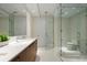 Bright bathroom featuring a clear glass shower, toilet, wood cabinets, and white countertop at 111 S Pineapple Ave # 813, Sarasota, FL 34236