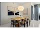 Bright dining room featuring modern light fixture, sleek wood table, and neutral toned chairs at 111 S Pineapple Ave # 813, Sarasota, FL 34236