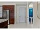 Hallway leading to a half bathroom with blue tiled walls, stainless refrigerator, and marble floors at 111 S Pineapple Ave # 813, Sarasota, FL 34236