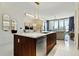 Modern kitchen with stainless steel appliances, island, and sliding glass doors to balcony at 111 S Pineapple Ave # 813, Sarasota, FL 34236