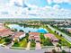 Aerial shot of a beautiful home overlooking a serene lake, surrounded by other homes in a well-planned community at 13112 Swiftwater Way, Bradenton, FL 34211