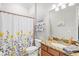 Well-lit bathroom featuring a vanity with granite countertop, decorative shower curtain, and a framed mirror at 13112 Swiftwater Way, Bradenton, FL 34211