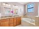 Elegant bathroom with a dual sink vanity, soaking tub, granite countertops, and stylish fixtures at 13112 Swiftwater Way, Bradenton, FL 34211