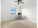 Bright room with large window and ceiling fan; showcasing neutral carpet and desk with chair, great for an office or bedroom at 13112 Swiftwater Way, Bradenton, FL 34211