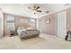 Inviting bedroom with neutral color scheme, a ceiling fan, and natural light from the windows at 13112 Swiftwater Way, Bradenton, FL 34211