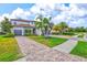 Lovely home with a three-car garage, brick driveway, tropical plants, and green lawn in a manicured community at 13112 Swiftwater Way, Bradenton, FL 34211
