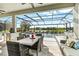 Elegant outdoor dining area with comfortable seating, a full kitchen, a screened enclosure and a view of a luxurious pool at 13112 Swiftwater Way, Bradenton, FL 34211