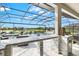 Granite-topped outdoor kitchen bar area overlooking a screened pool and spa, perfect for entertaining with style and comfort at 13112 Swiftwater Way, Bradenton, FL 34211