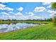 Picturesque pond view with clear reflections, surrounded by lush green grass and well-kept neighborhood homes at 13112 Swiftwater Way, Bradenton, FL 34211