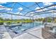 Beautiful pool and spa area with comfortable lounge seating, complemented by a picturesque lake view in a screened enclosure at 13112 Swiftwater Way, Bradenton, FL 34211
