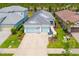 Aerial view of a well-manicured property featuring a three-car garage, lush landscaping, and a charming exterior at 13169 Steinhatchee Loop, Venice, FL 34293