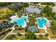 Aerial view featuring a resort-style pool, lap pool, and tiki bar, surrounded by lush landscaping at 13169 Steinhatchee Loop, Venice, FL 34293