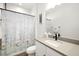 Bright bathroom featuring a white vanity, modern fixtures and tub shower with a beach-themed shower curtain at 13169 Steinhatchee Loop, Venice, FL 34293
