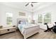 Bright bedroom with coastal decor, lots of natural light, wood-look floors, and a modern ceiling fan at 13169 Steinhatchee Loop, Venice, FL 34293