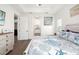 Bright bedroom featuring tray ceilings, wood floors, and a coastal-themed bedspread at 13169 Steinhatchee Loop, Venice, FL 34293