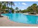 Large community pool surrounded by palm trees and lounge chairs at 13169 Steinhatchee Loop, Venice, FL 34293