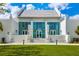 A contemporary building with large glass windows, a concrete staircase leading up to the entrance, and a well-manicured lawn at 13169 Steinhatchee Loop, Venice, FL 34293
