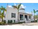 This modern two-story building has white exterior walls, decorative chimney tops, and a small, covered patio at 13169 Steinhatchee Loop, Venice, FL 34293