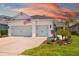 Home exterior boasting a manicured lawn, two-car garage, and patriotic American flag at 13169 Steinhatchee Loop, Venice, FL 34293