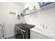 Clean laundry room with modern black washer and dryer, sink, and overhead storage at 13169 Steinhatchee Loop, Venice, FL 34293