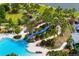 Aerial view of the community pool, showcasing a slide and lush landscaping; resort-style amenities at 13169 Steinhatchee Loop, Venice, FL 34293