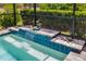 Close-up of a pool waterfall feature with turtle statues and a screened enclosure overlooking lush greenery at 13169 Steinhatchee Loop, Venice, FL 34293
