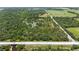 Aerial view of a wooded parcel situated near the highway, and open fields at 140 Cowpen Ln, Sarasota, FL 34240