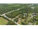 Expansive aerial view of lush, tree-filled acreage with custom home and private pond at 140 Cowpen Ln, Sarasota, FL 34240