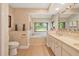Bright bathroom with double sink vanity, large window, soaking tub, and travertine flooring at 140 Cowpen Ln, Sarasota, FL 34240