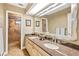 Bathroom with dual sinks, granite countertop, decorative mirror, and walk-in shower at 140 Cowpen Ln, Sarasota, FL 34240