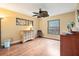 Bright bedroom featuring hardwood floors, two windows, and a unique ceiling fan at 140 Cowpen Ln, Sarasota, FL 34240
