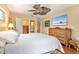 Bedroom with hardwood floors, ceiling fan, and large dresser at 140 Cowpen Ln, Sarasota, FL 34240