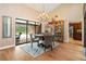 Open dining room with a chandelier, large window, and access to the kitchen at 140 Cowpen Ln, Sarasota, FL 34240