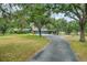 Long driveway leading to a charming home with mature trees and lush landscaping at 140 Cowpen Ln, Sarasota, FL 34240