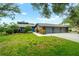 Brick home featuring a three-car garage, manicured lawn, and mature landscaping at 140 Cowpen Ln, Sarasota, FL 34240