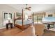 Spacious bedroom featuring hardwood floors, four-poster bed, and a serene view of the outdoor pool at 140 Cowpen Ln, Sarasota, FL 34240