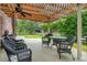 Covered outdoor dining area with wicker furniture and a view of lush greenery at 140 Cowpen Ln, Sarasota, FL 34240