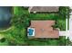 Aerial view of a home with screened-in pool, pond, and lush backyard at 1542 Ormond Ter, Parrish, FL 34219