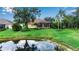 Backyard featuring screened-in lanai, mature trees, and pond at 1542 Ormond Ter, Parrish, FL 34219