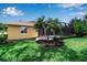 Beautiful backyard boasting mature landscaping, lush green lawn and a screened-in lanai at 1542 Ormond Ter, Parrish, FL 34219