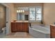 This bathroom features a garden tub, wood cabinets and tile floors at 1542 Ormond Ter, Parrish, FL 34219
