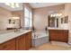 This bathroom features a garden tub, dual sinks and wood cabinets at 1542 Ormond Ter, Parrish, FL 34219