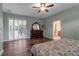 Light-filled bedroom with shuttered doors leading to the lanai, featuring wood floors and a ceiling fan at 1542 Ormond Ter, Parrish, FL 34219