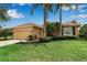 Charming single-story home features a lush lawn, mature landscaping, and a two-car garage at 1542 Ormond Ter, Parrish, FL 34219